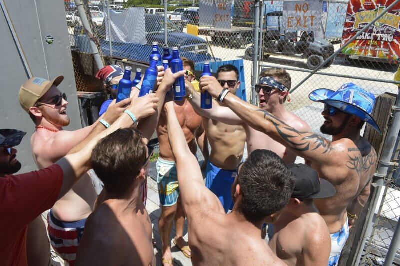 A group of guys at a bachelor party toasting on a boat