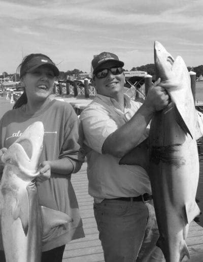 Two Guests Each Holding a Thrasher Shark